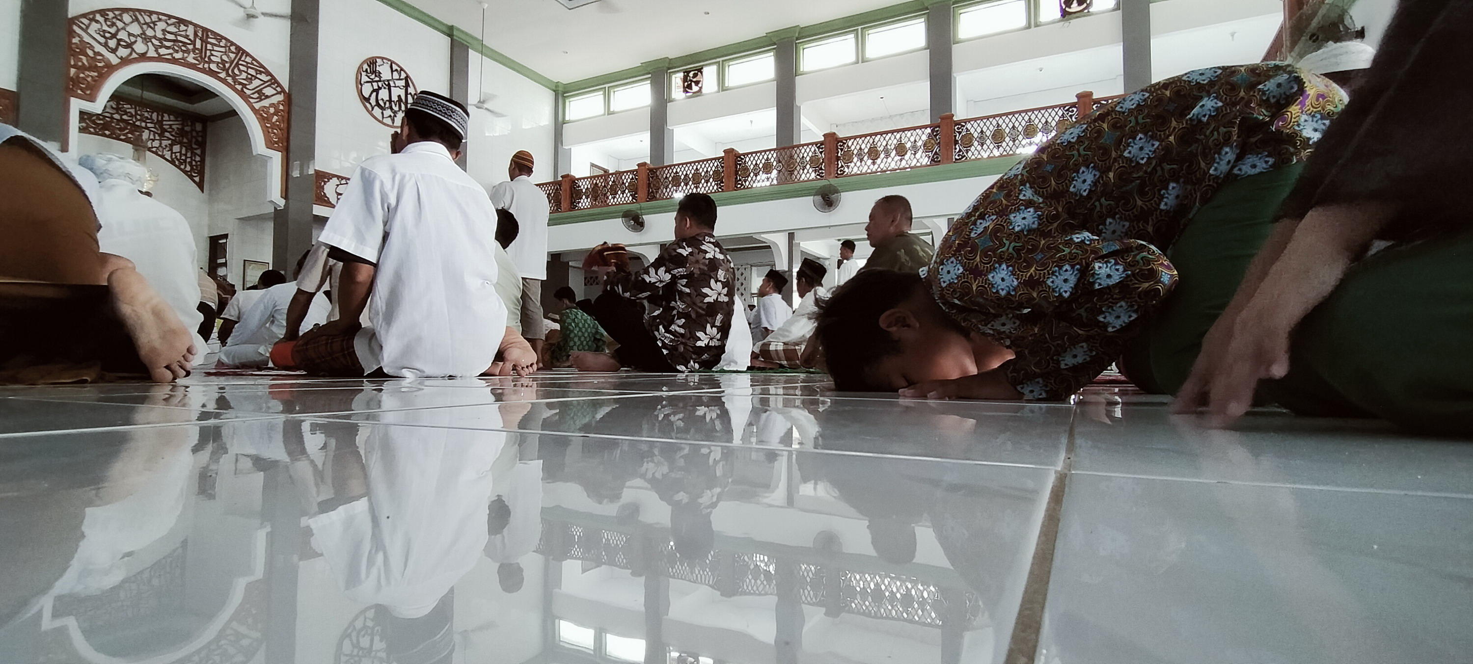 Warga Tetap Salat Jumat, Karpet Alas Salat Digulung, Saf Rapat Tetap Bersalaman